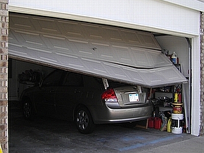 picture of garage door closing on top of a car.